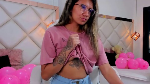 La brune tatouée aux lunettes a l'air incroyable et a envie de s'amuser avec vous