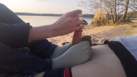 Travieso juego de pies y calcetines en público en la playa